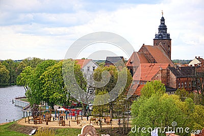 Cityscape of Havelberg at Havel river with its church St. Laurentius. Playground in front with people Editorial Stock Photo