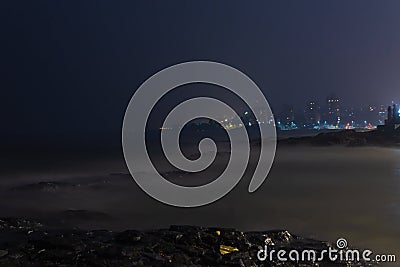 Cityscape at night with beach in the foreground Stock Photo