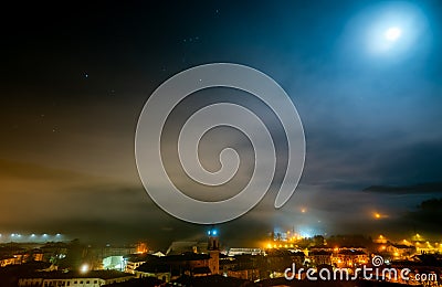 Cityscape in the night with stars in the sky. City in mist. Europe building in mist. City and orange light in the night. City Editorial Stock Photo