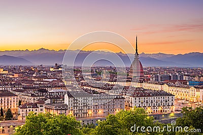 Cityscape of Torino Turin, Italy at dusk with colorful moody sky. The Mole Antonelliana towering on the illuminated city below. Stock Photo