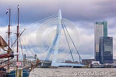 Cityscape - view of the moored sailboat on a background of skyscrapers district Feijenoord city of Rotterdam and the Erasmus Bridg Editorial Stock Photo