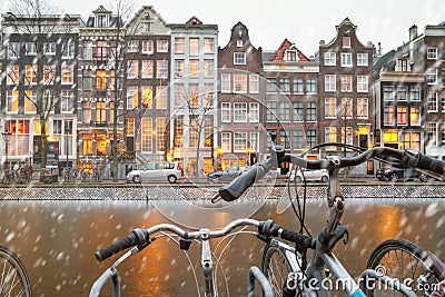 Cityscape - winter view from bicycles to houses with festive decorations and a city channel with boats, city of Amsterdam Editorial Stock Photo