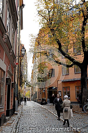 Citystreet with houses in traditional swedish colors on an fall day in Gamla Stan Editorial Stock Photo