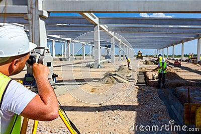Civil engineer, geodesist is working with total station on a building site Editorial Stock Photo