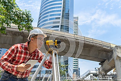 Civil engineer land survey with tacheometer or theodolite equipment. Worker Checking construction site on the road. Surveyor Stock Photo