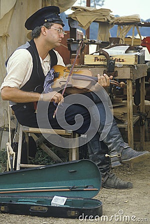 Civil War participant playing fiddle in camp scene during recreation of Battle of Manassas marking the start of the Civil War Editorial Stock Photo