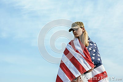 Civilian woman in her husband`s military cap. A widow with a flag of the united states left without her husband. Memorial Day to Stock Photo