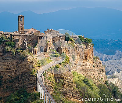 The famous Civita di Bagnoregio hit by the sun on a stormy day. Province of Viterbo, Lazio, Italy. Stock Photo