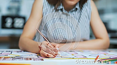 Ciérrese para arriba del arquitecto de sexo femenino que dibuja hacia fuera y después que corta el componente para el proyecto de metrajes Ciérrese para arriba del arquitecto de sexo femenino que dibuja hacia fuera y después que corta el componente para el proyecto de metrajes