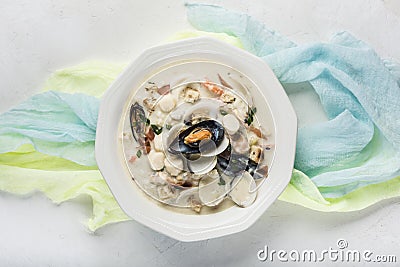 Clam chowder in a white plate. The main ingredients are shellfish, broth, butter, potatoes and onions Stock Photo