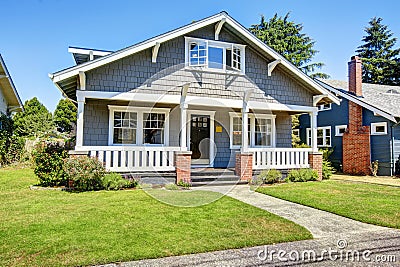 Clapboard siding house exterior. Large entance porch with brick Stock Photo