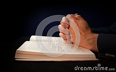 Clasped hands on a bible Stock Photo