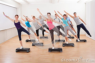 Class doing aerobics balancing on boards Stock Photo