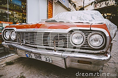 Classic American retro car under car case on the street. Bumper and headlight of red vintage car. Turkey, Cappadocia Editorial Stock Photo