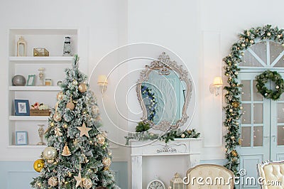 Classic apartments with a white fireplace, decorated fir tree, sofa, large doors with windows and chandelier. Christmas morning Stock Photo