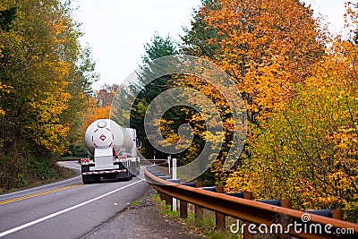 Classic big rig with propane tank on winding autumn road Stock Photo