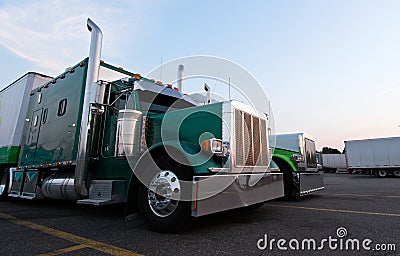 Classic big rig semi trucks in line on truck stop Stock Photo