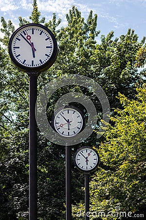 Classic black and white analog clocks with synchronized time show teamwork and synced project management with time management and Stock Photo