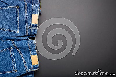 Classic blue jeans. Casual pants clothing blue jeans with brown blank leather labels on black background with copy space Stock Photo