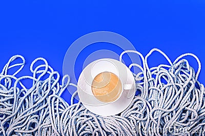 Classic blue layout with minimalistic cotton white rope and cup of coffee. Stock Photo