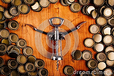 Classic bottle opener and pile of beer bottle caps Stock Photo