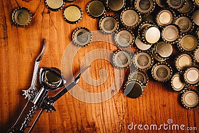 Classic bottle opener and pile of beer bottle caps Stock Photo