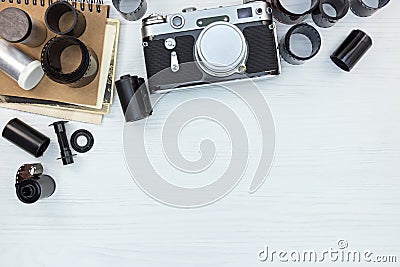 classic camera, negative films rolls and notebook on white wooden flat view Stock Photo