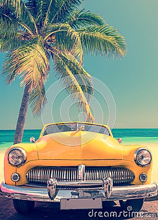 Classic car on a tropical beach with palm tree, vintage style Stock Photo