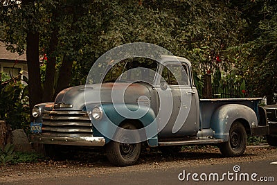 Classic Chevy truck parked in a country neighborhood under a green tree Editorial Stock Photo