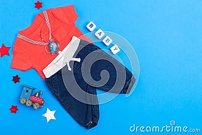 Classic children`s clothing on a blue background. Baby clothes collage. The boy is wearing a red shirt and jeans. pacifier and to Stock Photo