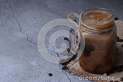 Classic cold drink Iced Coffee in a beautiful presentation in a glass cocktail jar on a gray background Stock Photo