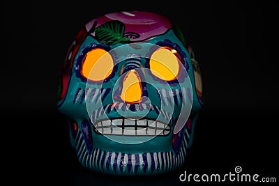 A classic colorful Mexican skull with bright orange eyes on a black background Stock Photo