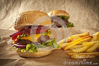 Classic deluxe cheeseburger with lettuce, onions, tomato and pickles on a sesame seed bun Stock Photo