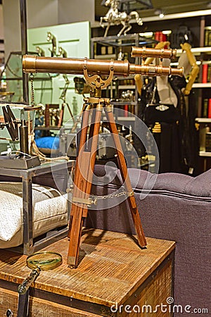 Classic design telescope with wooden leg support in a shop selling vintage goods Stock Photo