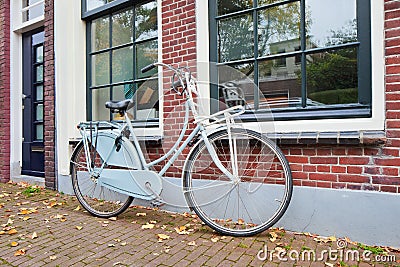 Classic Dutch bicycle parked against brick house in autumn, Gouda, Netherlands Stock Photo