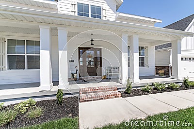 Classic front porch of a house with white siding exterior Stock Photo