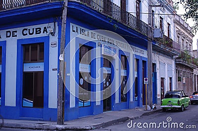 Classic green car in front of a vivid blue building Editorial Stock Photo