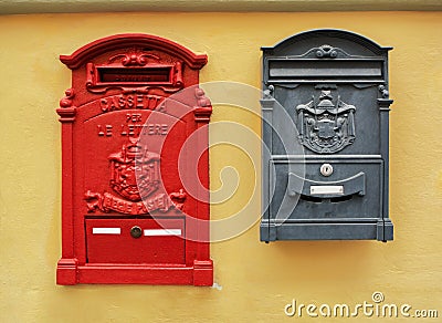 Classic old red and black Italian postboxes on a yellow painted stucco wall Stock Photo