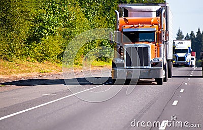 Classic orange semi truck reefer trailer on high way Stock Photo