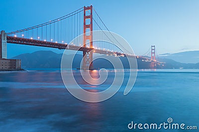 Classic panoramic view of famous Golden Gate Bridge seen from San Francisco harbour in beautiful evening light on a dusk. Stock Photo