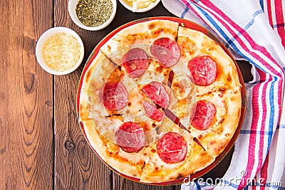 Classic pepperoni pizza in a plate on a wooden background Stock Photo