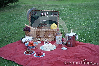 A classic picnic basket with fruits, meringue, vegetables, red wine, rose wine and champagne Stock Photo