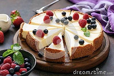 Classic plain New York Cheesecake sliced on wooden board Stock Photo