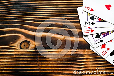 Classic playing cards on dark brown wooden table. Scattered cards. Stock Photo