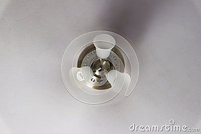 Classic polished brass ceiling fan with light in full motion. Stock Photo