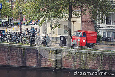 Classic red Piaggio APE three-wheeler parked on the street Editorial Stock Photo