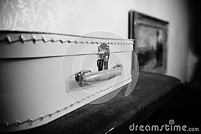 Classic retro suitcase in black and white photo, laying on the wooden surface Stock Photo