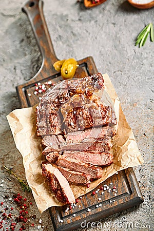 Classic ribeye steak served in waxed paper on wooden cutting board Stock Photo