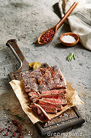 Classic ribeye steak served in waxed paper on wooden cutting board Stock Photo