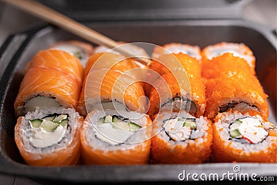 Classic rolls with salmon, rice, seaweed, cheese, crab and cucumber. Japanese food. delivery to work and home Stock Photo